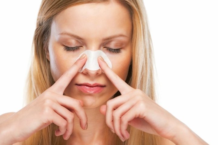 Portrait-of-teenage-girl-applying-clear-up-strips-on-nose (1)